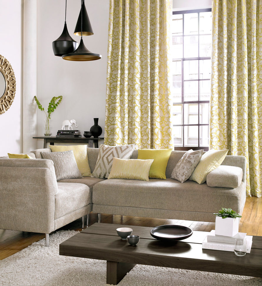 salon avec majorité couleur jaune. Table canapé avec fenêtre et rideaux motif